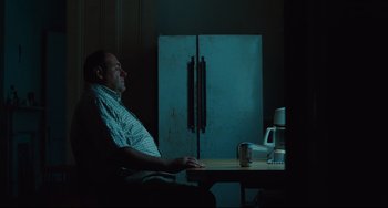 Movie still from “Welcome to the Rileys” (2010), directed by Jake Scott – A man sitting in front of an open refrigerator in a dark room; Medium shot, High angle