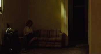 Movie still from “Welcome to the Rileys” (2010), directed by Jake Scott – A person sitting on a couch in a room; Wide shot, Low angle