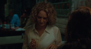 Movie still from “Welcome to the Rileys” (2010), directed by Jake Scott – A woman in a white shirt is eating a sandwich; Close Up shot, Over the shoulder angle