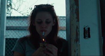 Movie still from “Welcome to the Rileys” (2010), directed by Jake Scott – A woman is lighting a cigarette in front of a window; Medium shot, Low angle