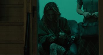 Movie still from “Welcome to the Rileys” (2010), directed by Jake Scott – A woman sitting on a couch holding a cell phone; Medium shot, High angle