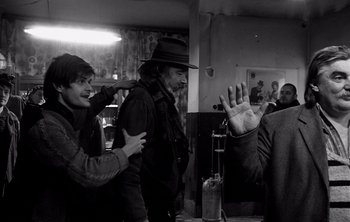 Movie still from “Werckmeister Harmonies” (2000), directed by Ágnes Hranitzky – A man in a hat is waving at a man in a hat; Medium shot, Over the shoulder angle