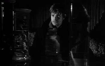Movie still from “Werckmeister Harmonies” (2000), directed by Ágnes Hranitzky – A black and white photo of a man looking at the camera; Close Up shot, Over the shoulder angle