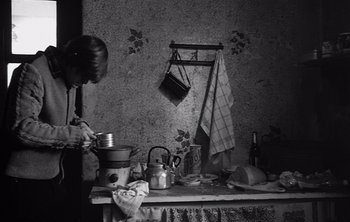 Movie still from “Werckmeister Harmonies” (2000), directed by Ágnes Hranitzky – A black and white photo of a cluttered kitchen; Medium shot, High angle