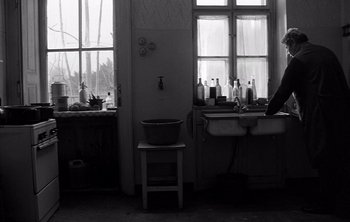 Movie still from “Werckmeister Harmonies” (2000), directed by Ágnes Hranitzky – A black and white photo of a kitchen with a sink and a window; Wide shot, Low angle