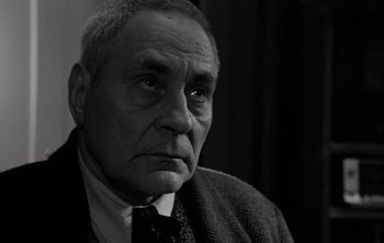 Movie still from “Werckmeister Harmonies” (2000), directed by Ágnes Hranitzky – An older man wearing a suit and a tie; Close Up shot, Low angle
