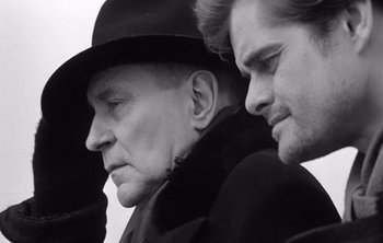 Movie still from “Werckmeister Harmonies” (2000), directed by Ágnes Hranitzky – A man in a hat and a man in a black hat; Close Up shot, Over the shoulder angle