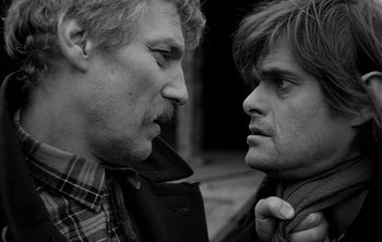 Movie still from “Werckmeister Harmonies” (2000), directed by Ágnes Hranitzky – Two men face each other and one has a beard; Close Up shot, Over the shoulder angle