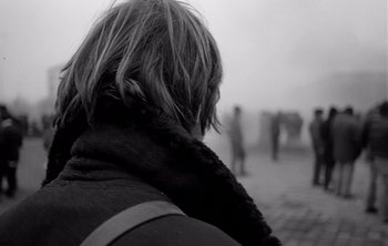 Movie still from “Werckmeister Harmonies” (2000), directed by Ágnes Hranitzky – A woman with a scarf on her head looking at a group of people in the distance; Close Up shot, Over the shoulder angle