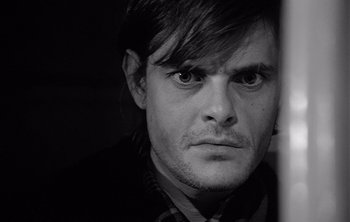 Movie still from “Werckmeister Harmonies” (2000), directed by Ágnes Hranitzky – Black and white photograph of a young man with long hair; Close Up shot, Over the shoulder angle