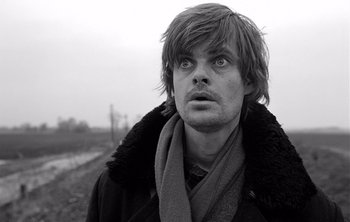 Movie still from “Werckmeister Harmonies” (2000), directed by Ágnes Hranitzky – Black and white photograph of a man in a field; Close Up shot, Low angle