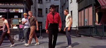 Movie still from “West Side Story” (1961), directed by Jerome Robbins – A group of young men walking down a sidewalk; Wide shot, Low angle