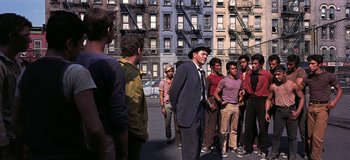 Movie still from “West Side Story” (1961), directed by Jerome Robbins – A group of men standing on the side of the street; Wide shot, High angle