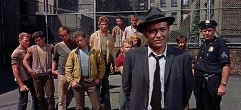 Movie still from “West Side Story” (1961), directed by Jerome Robbins – A group of men standing next to each other on a sidewalk; Medium shot, Low angle