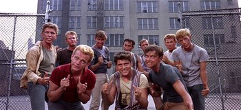 Movie still from “West Side Story” (1961), directed by Jerome Robbins – A group of young men standing next to each other in front of a building; Medium shot, High angle