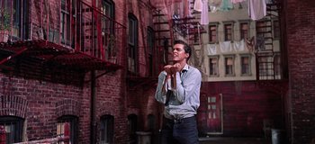 Movie still from “West Side Story” (1961), directed by Jerome Robbins – A man standing in front of a brick building; Medium shot, Low angle