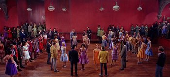 Movie still from “West Side Story” (1961), directed by Jerome Robbins – A group of people standing in a circle on a dance floor; Extreme Wide shot, High angle