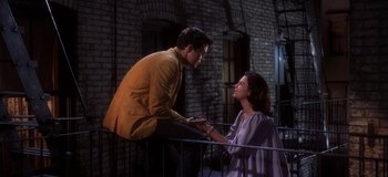 Movie still from “West Side Story” (1961), directed by Jerome Robbins – A man and a woman standing next to a railing; Medium shot, High angle