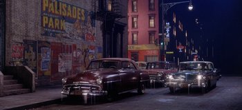 Movie still from “West Side Story” (1961), directed by Jerome Robbins – A group of old cars parked on the side of the street; Extreme Wide shot, High angle