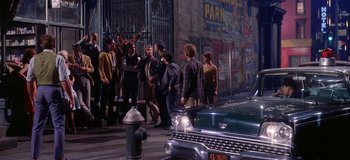 Movie still from “West Side Story” (1961), directed by Jerome Robbins – A group of people standing next to a fire hydrant; Wide shot, Over the shoulder angle