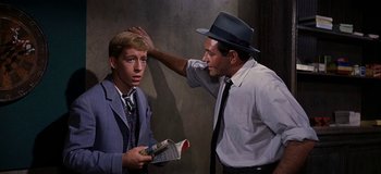 Movie still from “West Side Story” (1961), directed by Jerome Robbins – A man in a suit and a man in a hat; Medium shot, Over the shoulder angle