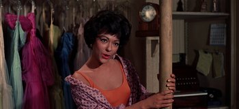 Movie still from “West Side Story” (1961), directed by Jerome Robbins – A woman holding a pole in front of a clock; Close Up shot, Low angle