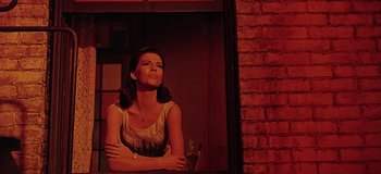 Movie still from “West Side Story” (1961), directed by Jerome Robbins – A woman standing in front of a brick wall; Medium shot, Low angle