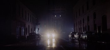 Movie still from “West Side Story” (1961), directed by Jerome Robbins – A man riding a motorcycle down a street at night; Extreme Wide shot, Low angle