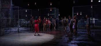 Movie still from “West Side Story” (1961), directed by Jerome Robbins – A group of people standing in a parking lot at night; Wide shot, High angle