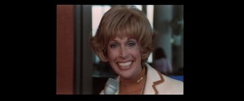 Movie still from “Westworld” (1973), directed by Michael Crichton – A person wearing a suit and smiling; Close Up shot, Low angle