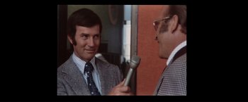 Movie still from “Westworld” (1973), directed by Michael Crichton – A man is being interviewed by another man in a suit; Close Up shot, Over the shoulder angle