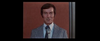 Movie still from “Westworld” (1973), directed by Michael Crichton – A man in a suit and tie holding a microphone; Close Up shot, Low angle