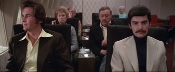 Movie still from “Westworld” (1973), directed by Michael Crichton – A group of people sitting in a row of seats; Medium shot, High angle