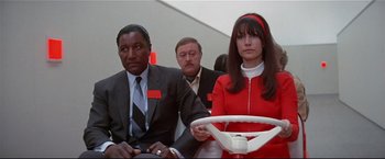 Movie still from “Westworld” (1973), directed by Michael Crichton – A group of men and a woman sitting next to each other; Medium shot, Low angle