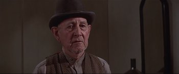 Movie still from “Westworld” (1973), directed by Michael Crichton – An older man wearing a hat and a vest; Close Up shot, Low angle