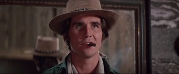 Movie still from “Westworld” (1973), directed by Michael Crichton – A person wearing a hat and smoking a cigarette; Close Up shot, Low angle