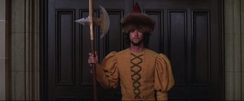 Movie still from “Westworld” (1973), directed by Michael Crichton – A man dressed in medieval clothing holding an axe; Medium shot, Low angle