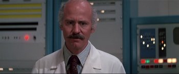 Movie still from “Westworld” (1973), directed by Michael Crichton – An older man in a white lab coat and a tie; Close Up shot, Low angle