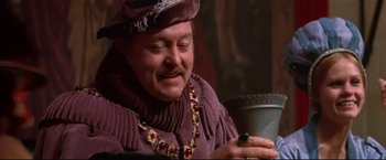 Movie still from “Westworld” (1973), directed by Michael Crichton – A man in a purple outfit looking down at a black object; Close Up shot, High angle