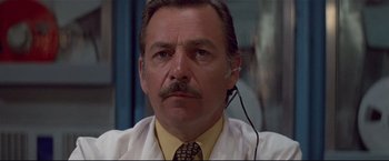 Movie still from “Westworld” (1973), directed by Michael Crichton – An older man wearing a white lab coat and a tie; Close Up shot, Low angle