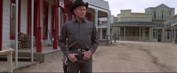 Movie still from “Westworld” (1973), directed by Michael Crichton – A man wearing a cowboy hat and holding a gun in his hand; Medium shot, Low angle