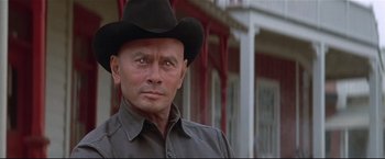 Movie still from “Westworld” (1973), directed by Michael Crichton – A man wearing a cowboy hat in front of a building; Close Up shot, Low angle