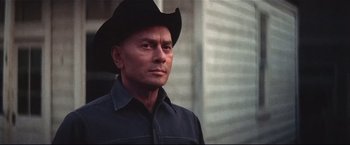 Movie still from “Westworld” (1973), directed by Michael Crichton – A man wearing a black cowboy hat and a black shirt; Close Up shot, Low angle