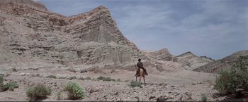 Movie still from “Westworld” (1973), directed by Michael Crichton – A man riding a horse in the desert; Extreme Wide shot, Low angle