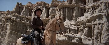 Movie still from “Westworld” (1973), directed by Michael Crichton – A man riding a horse in the middle of the desert; Wide shot, Low angle
