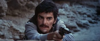 Movie still from “Westworld” (1973), directed by Michael Crichton – A man holding a gun while wearing a jacket; Close Up shot, Low angle