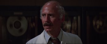 Movie still from “Westworld” (1973), directed by Michael Crichton – An older man wearing a white jacket and a tie; Close Up shot, Low angle