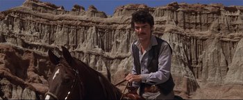 Movie still from “Westworld” (1973), directed by Michael Crichton – A man sitting on top of a brown horse; Medium shot, Low angle