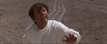 Movie still from “Westworld” (1973), directed by Michael Crichton – A man in a white shirt is standing in the dirt; Close Up shot, Low angle