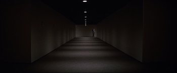 Movie still from “Westworld” (1973), directed by Michael Crichton – A person is standing in a dark hallway; Extreme Wide shot, High angle